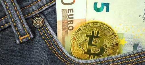Erziehungsberater Gehalt - 50 Euro, 5 Euro Schein und ein Bitcoin stecken in der Hosentasche einer Jeans