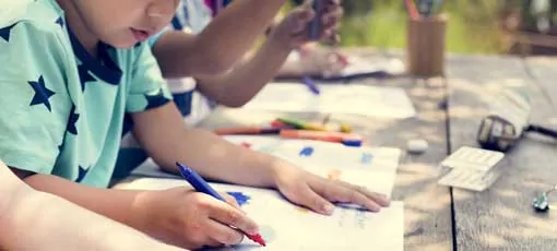 Kinder malen zusammen an einem Tisch